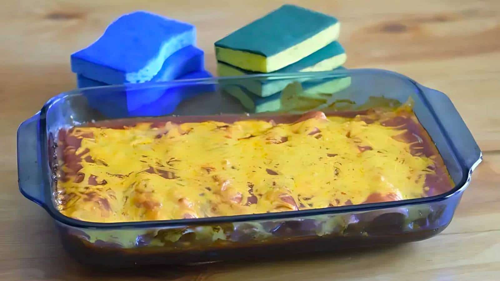 A bowl of fusilli pasta with ground beef, topped with chopped green onions, sits on a striped cloth.