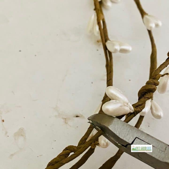 Wire cutters and grapevine on farmhouse wreath.