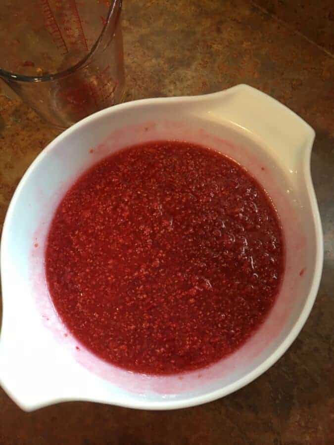 Crushed everbearing raspberries in bowl with sugar.