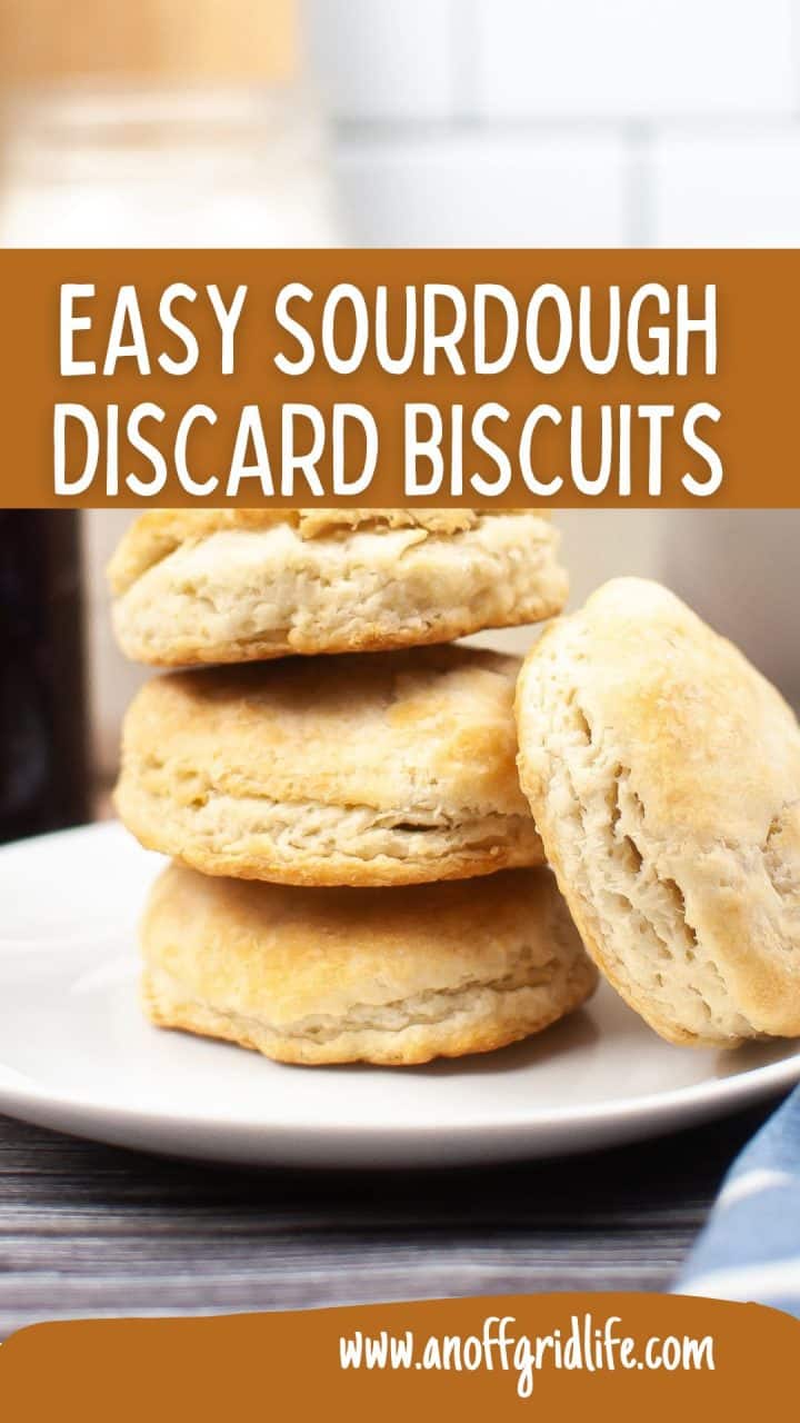 A stack of four golden-brown sourdough discard biscuits on a white plate, with the text "Easy Sourdough Discard Biscuits" and a website URL, www.anoffgridlife.com.