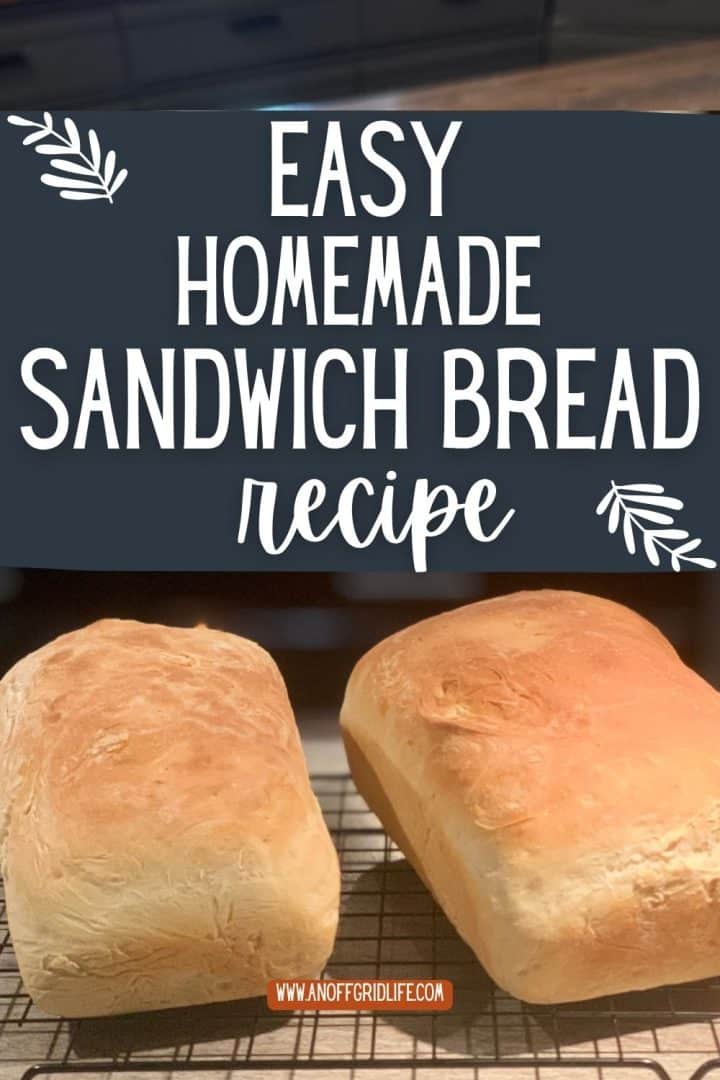 Two freshly baked loaves of sandwich bread are cooling on a wire rack below a sign that reads, "Easy Homemade Sandwich Bread Recipe.