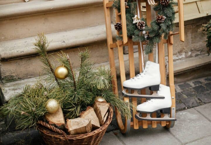 A pair of ice skates and a basket of christmas decorations.