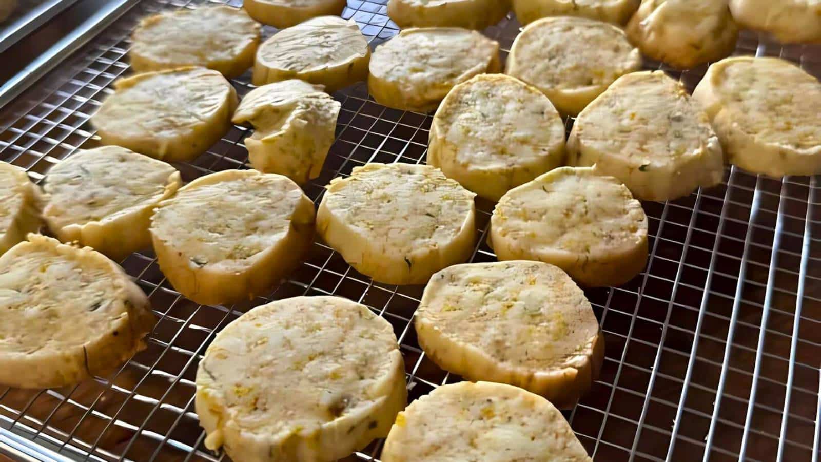Slices of raw cookie dough placed on a wire cooling rack, ready for baking.