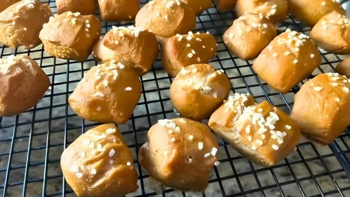 Pieces of pretzel bites topped with salt on a cooling rack.