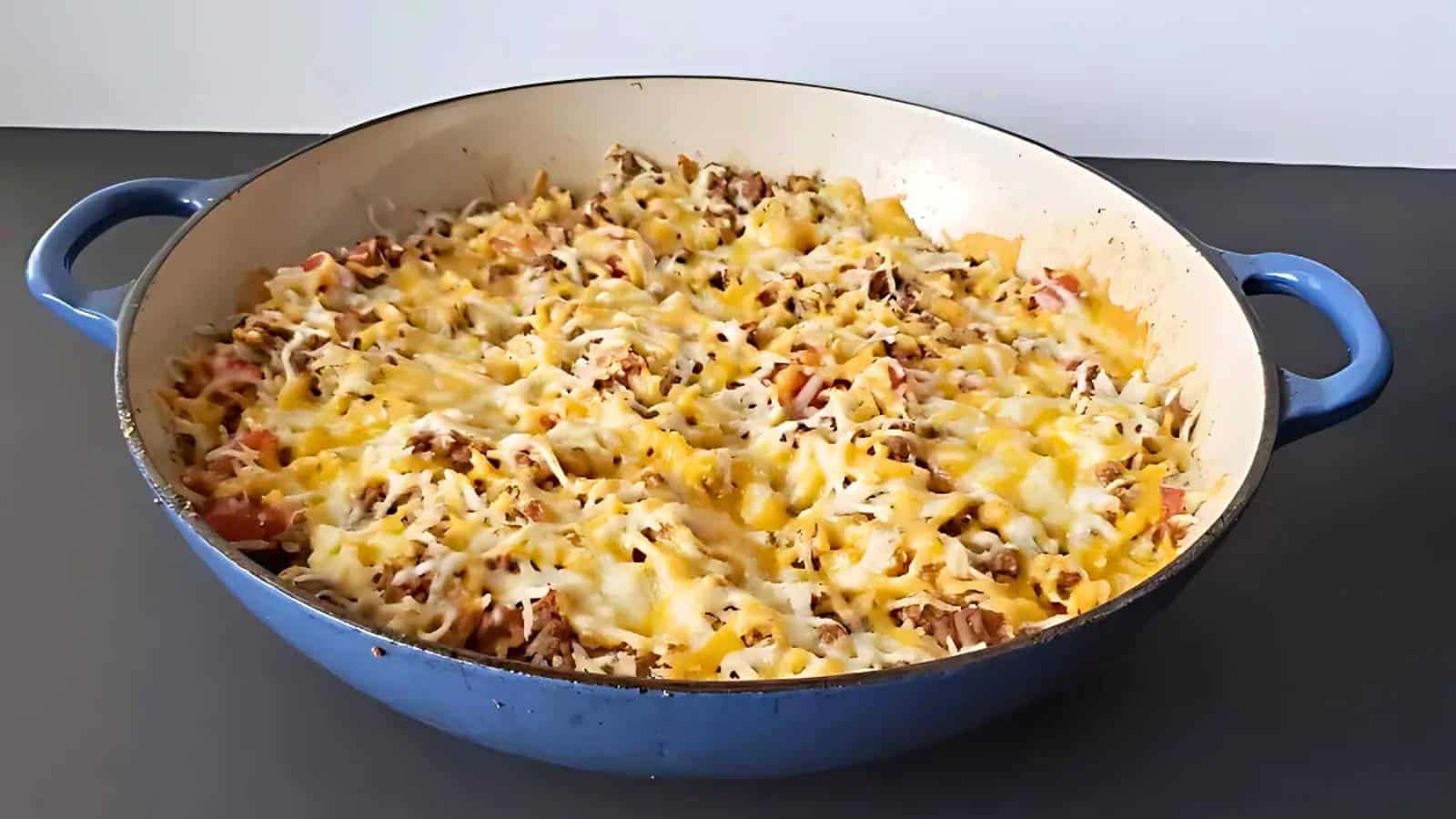 A dish of baked bread stuffing with herbs, featuring golden-brown bread cubes in a blue baking dish.