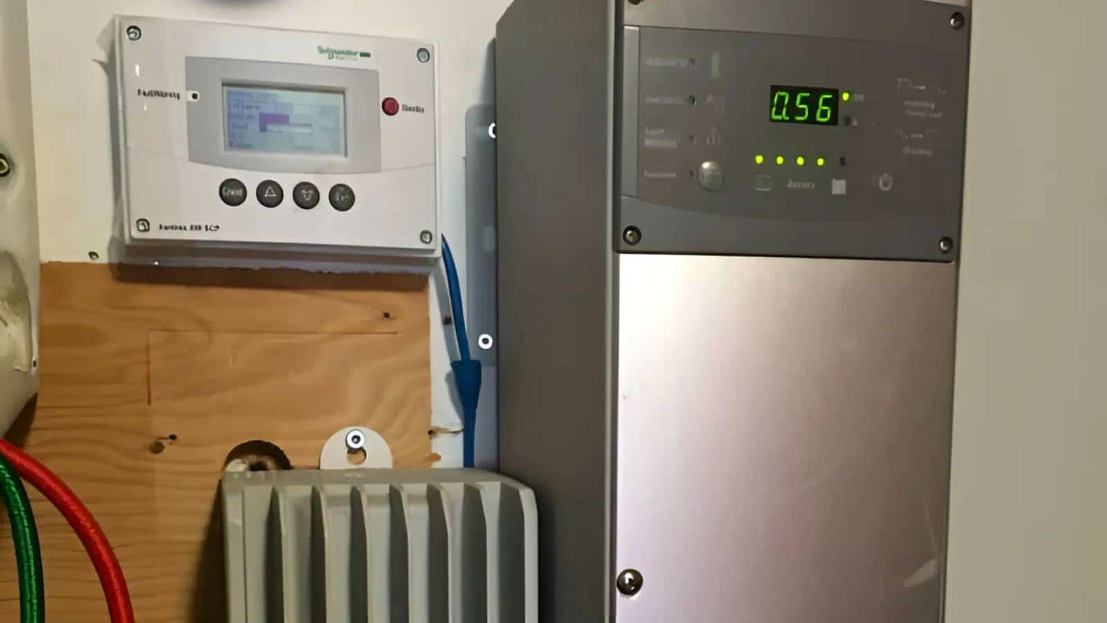 Wall-mounted digital control panels and a silver electronic device with a display showing "0.56" and various buttons. Cables are visible near the lower part of the setup.