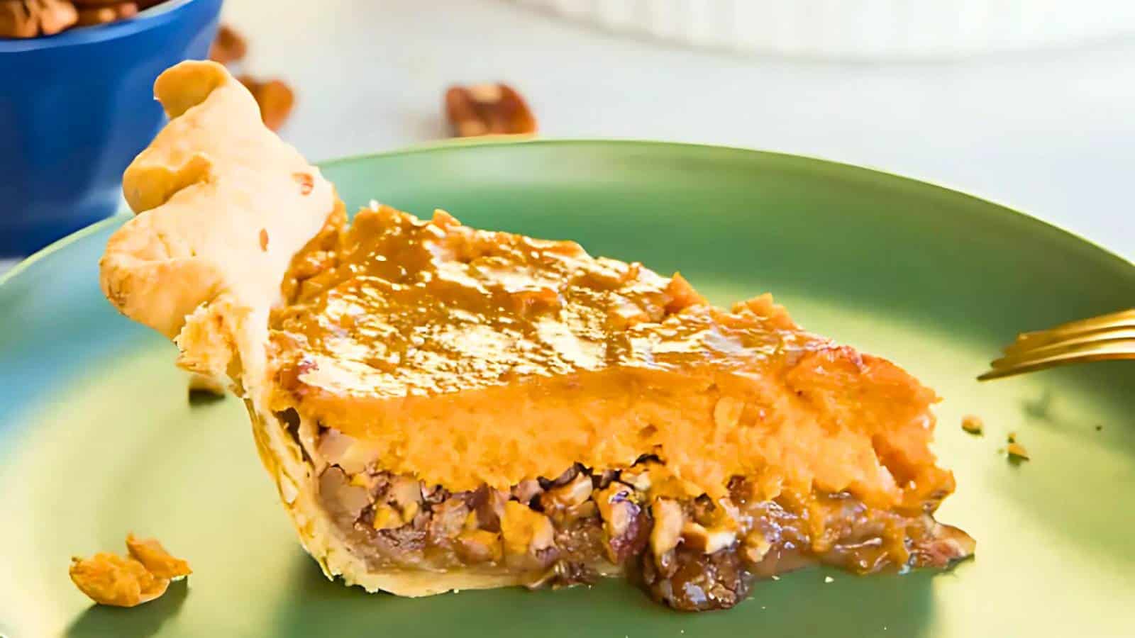 A slice of pie with a flaky crust, nut filling, and caramelized top on a green plate with a fork nearby.