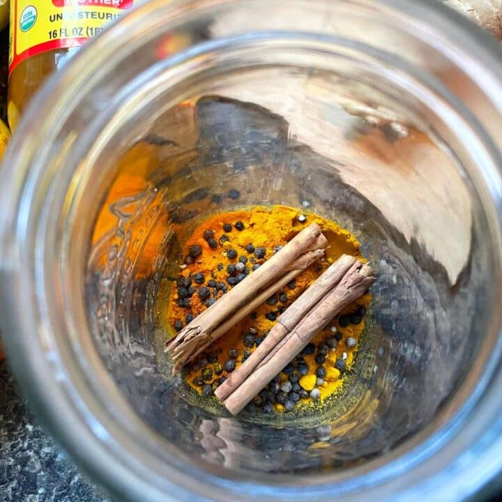 A jar with spices and cinnamon in it.
