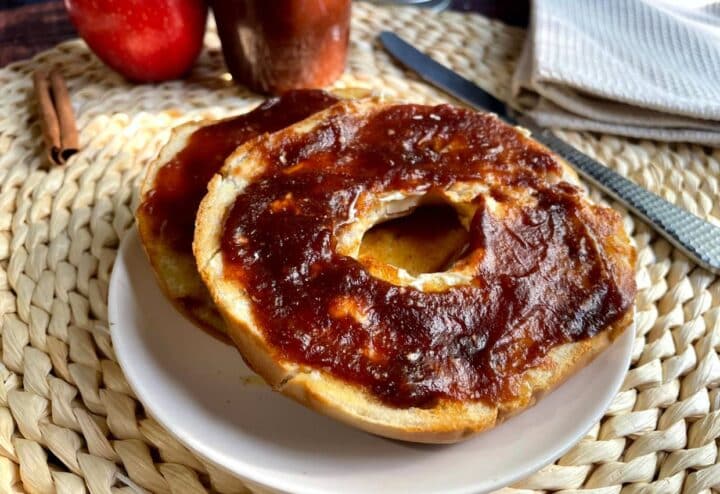 A plate with a bagel and apple butter on it.