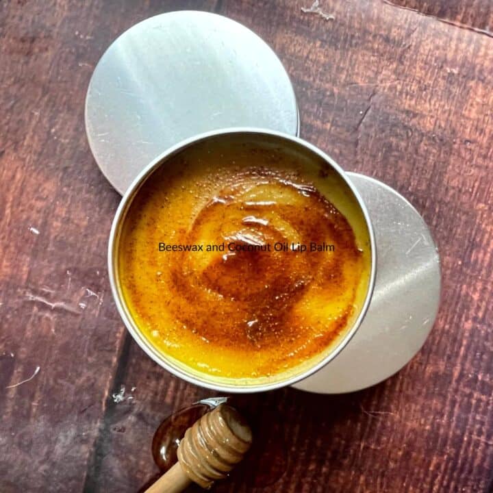 A tin of homemade beeswax and coconut oil lip balm and a wooden spoon.