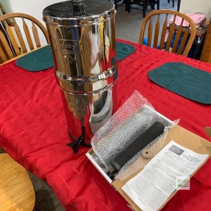 Big Berkey water filter and extra filters on table.
