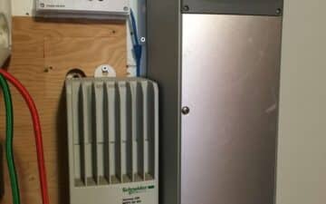 A wall mounted charge controller and inverter setup.