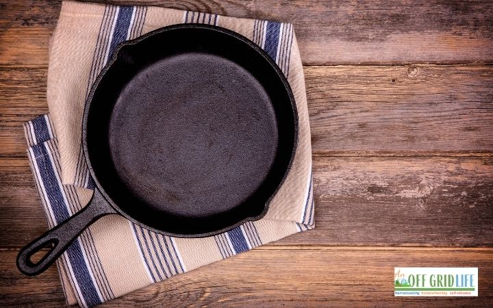 a picture of a single cast iron skillet on a blue and white wash cloth