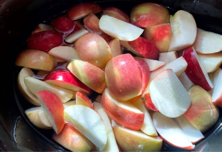 Sliced apples in a pot of water.