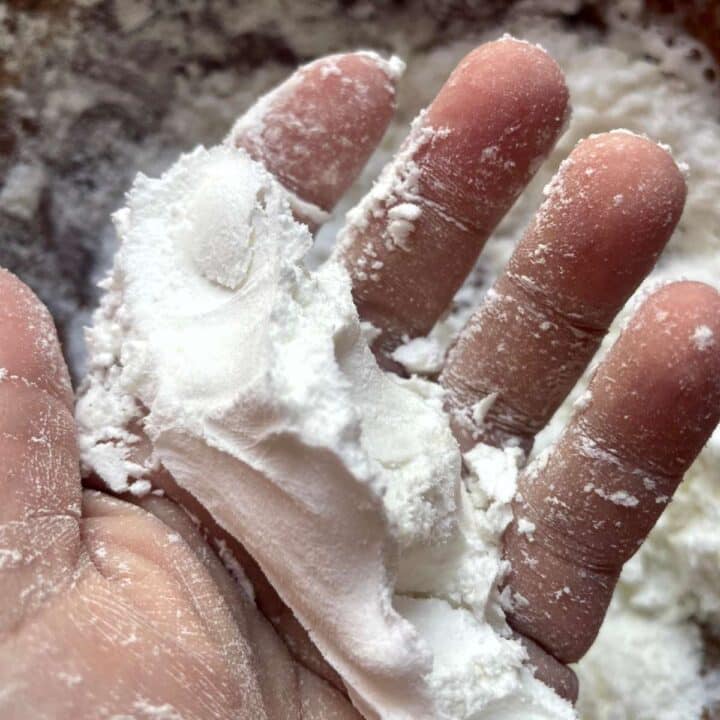 A person's hand holding shower steamer ingredients.