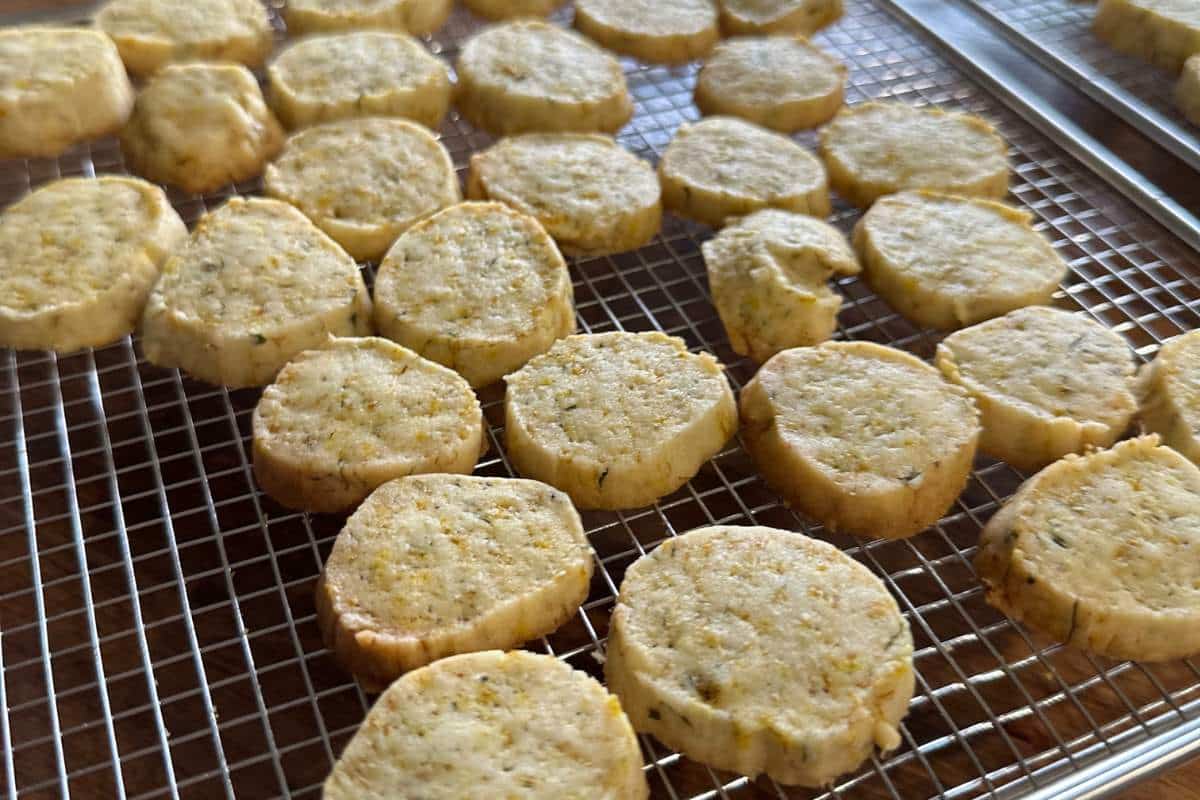 Freshly baked round dandelion shortbread cookies cooling on a wire rack.