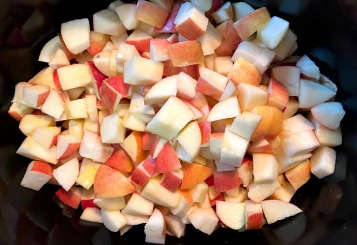 Sliced apples in a bowl on top of a stove.