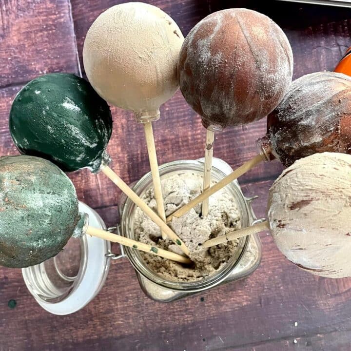 Vintage ball ornaments in a jar on a table.