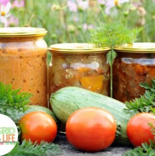 Canned vegetables in jars with fresh vegetables outdoors