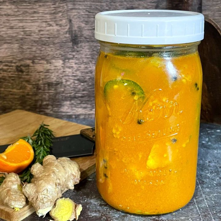 A mason jar with fire cider on a cutting board.