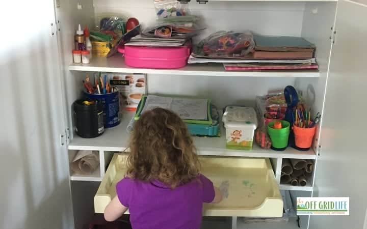 Child at homeschool shelving unit