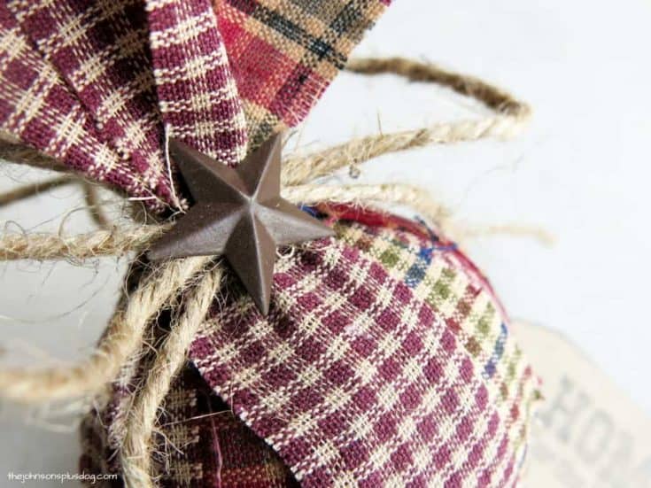 A plaid Christmas ornament with a star on it, perfect for pioneer-inspired holiday crafts for kids.