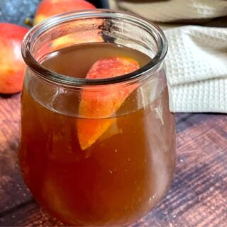 A mason jar filled with apple cider.