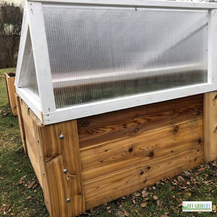 a picture of a cold frame garden with a wooden base and a plastic white top