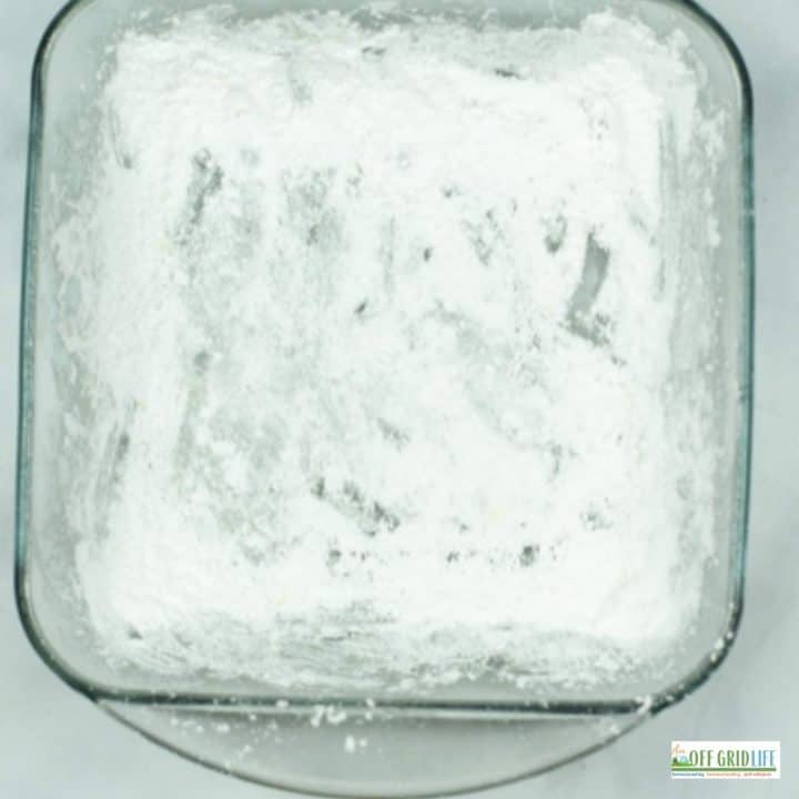 a square glass baking dish with powdered sugar dusting the bottom