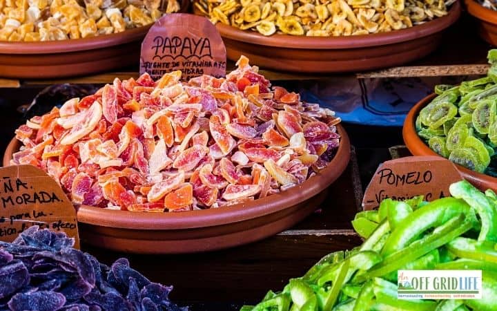 wooden bowls of dehydrated fruits, including papaya and pomelo