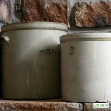 two white stone crocks with a brick wall background