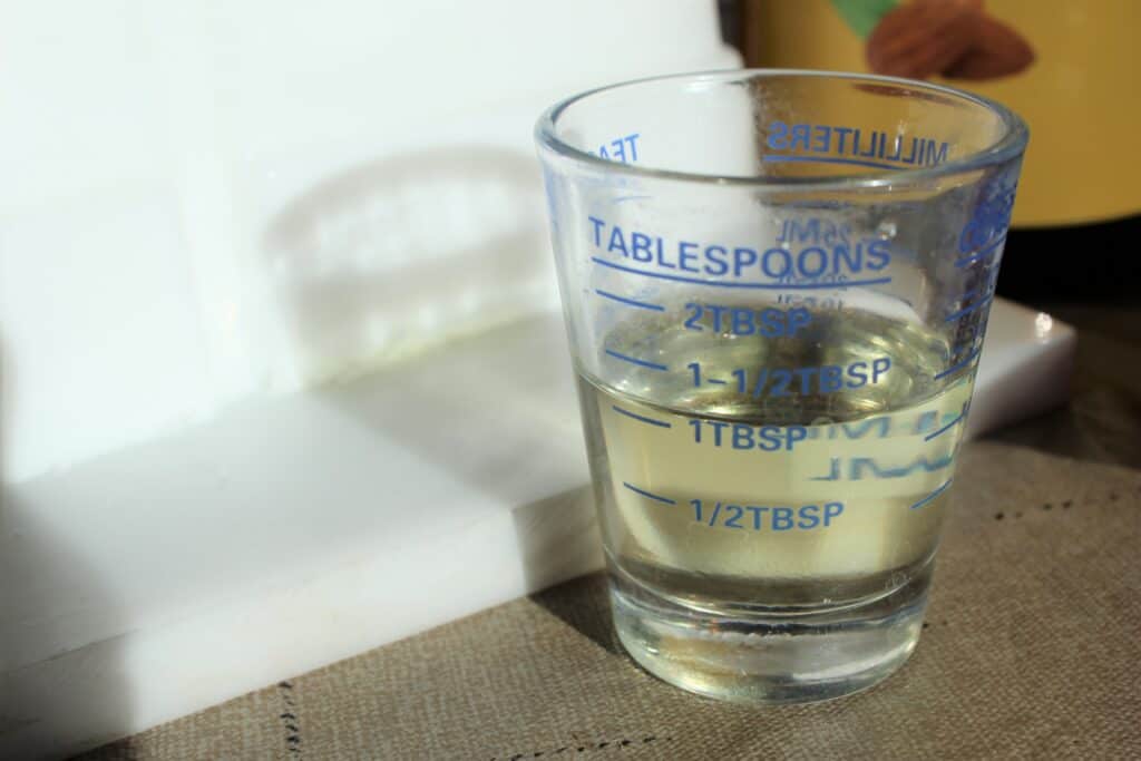 almond oil in measuring cup for goat milk soap