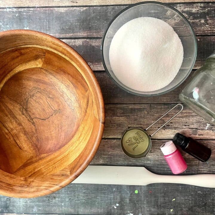 A wooden bowl filled with sugar and a wooden spoon.