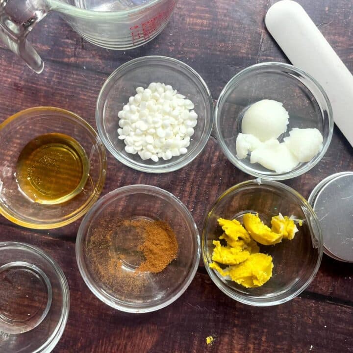 The ingredients for a recipe for homemade beeswax and coconut oil lip balm made with honey and shea butter.