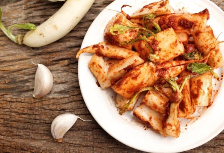 Korean kimchi on a plate with garlic and onions.