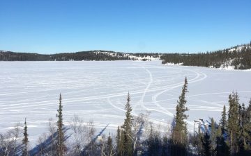 Living off the grid in winter view of lake covered in snow and ice.