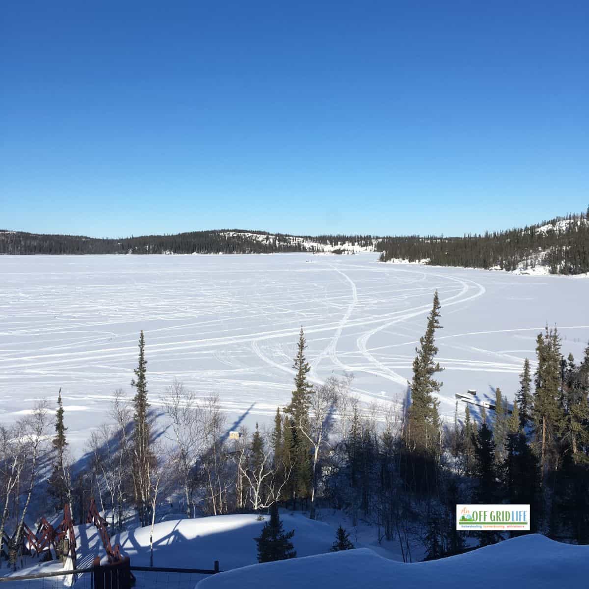 Living off the grid in winter view of lake covered in snow and ice.