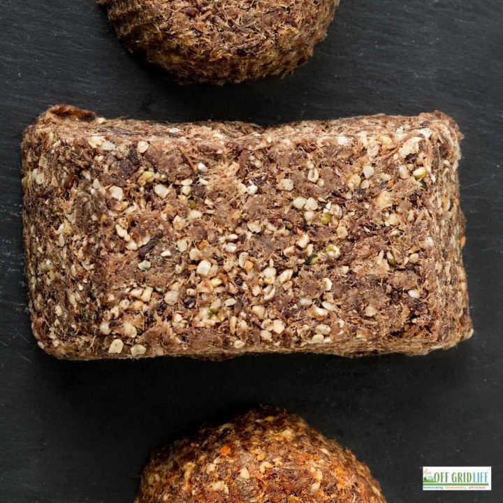 A picture of 3 pieces of pemmican made with game meat and a black background.