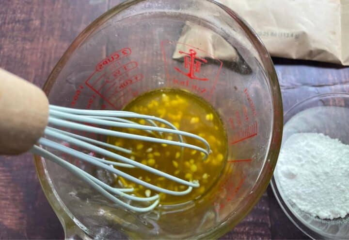 Mixing DIY natural sunscreen in measuring cup.