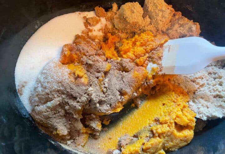 The ingredients for pumpkin butter in a bowl with a spoon.