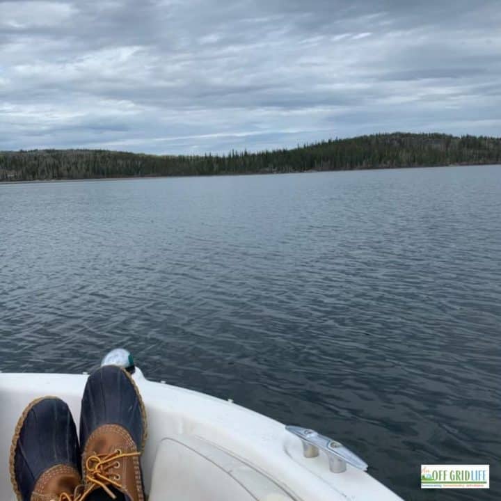 a picture off grid of someones feet up on a boat looking at open water.