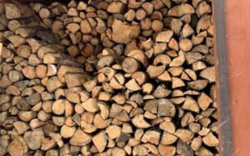 a large stack of split and dried wood in an off grid wood shack