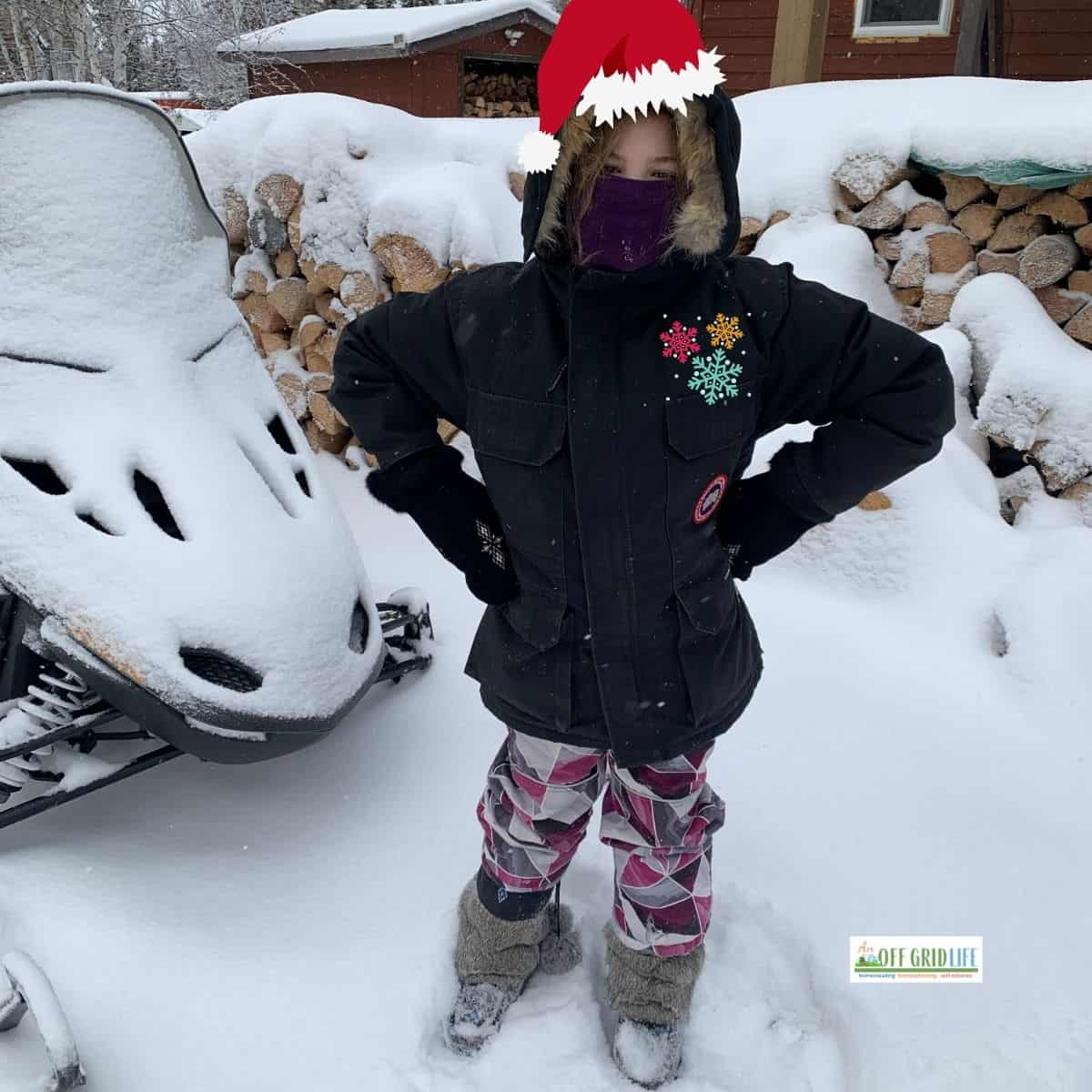 Child outdoors in winter with snow and with Santa out on