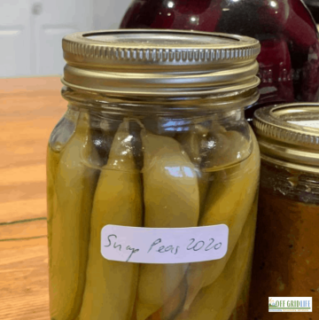 three jars of pickled vegetables on a wooden counter