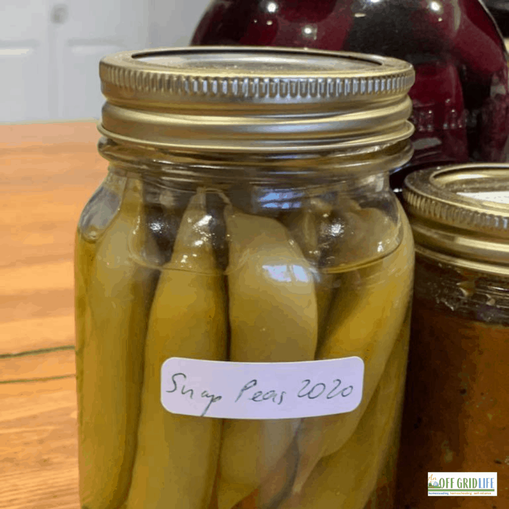 three jars of pickled vegetables on a wooden counter