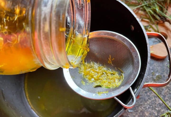 Pouring dandelion infusion through strainer.
