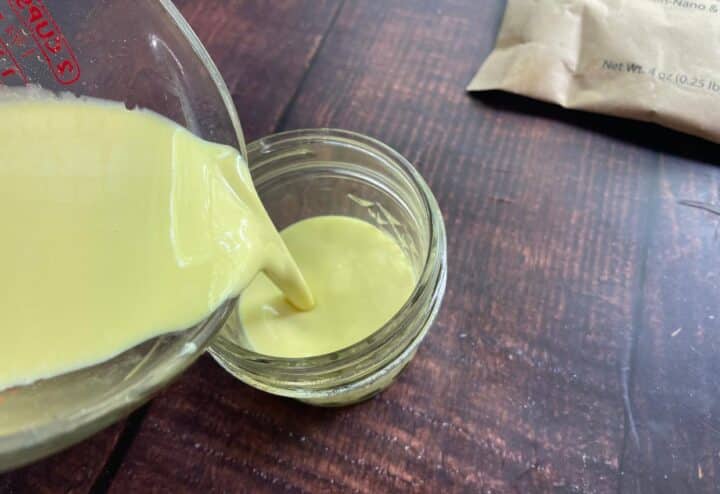 Pouring sunscreen into glass jar.