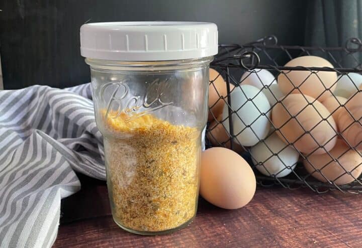 Dehydrated eggs in jar with basket of fresh eggs behind.