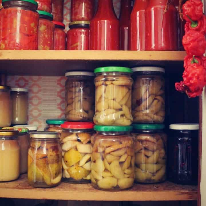 Preserves and homemade sauces in a prepper pantry.