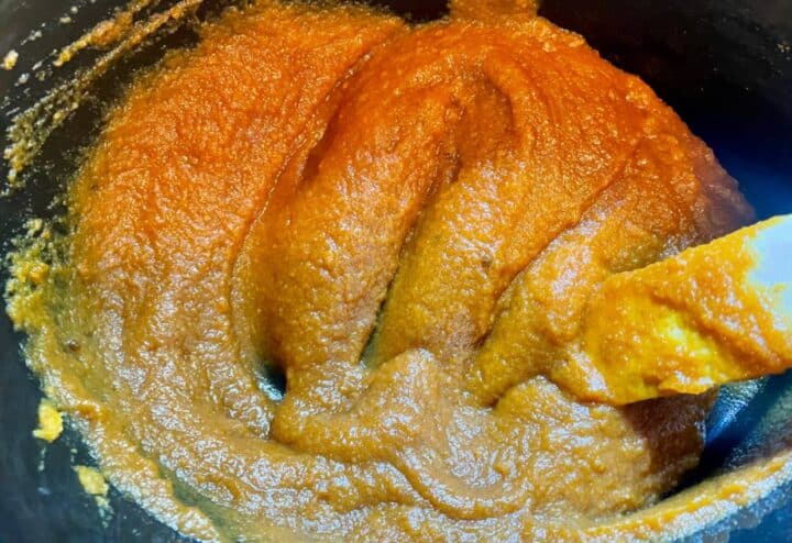 Pumpkin butter in a pot with a spoon.